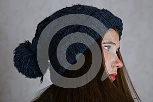 Teenage girl in knitted blue hat with pompom