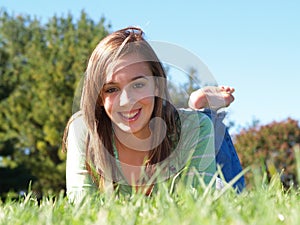 Teenage girl laying in grass