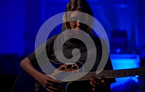 Teenage girl learning to play guitar