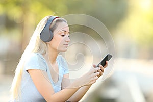 Teenage girl listening to music on her phone with headphones