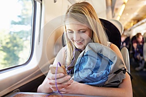 Teenage Girl Listening To Music On Train Journey