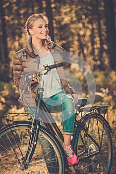 Teenage girl listens music on a bicycle outdoors