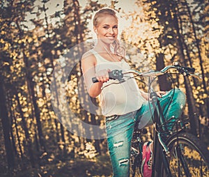 Teenage girl listens music on a bicycle outdoors