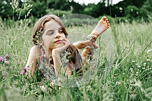 Teenage girl with long hair and bare feet  in the grass