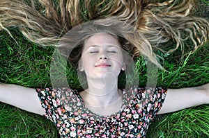 teenage girl with long hair relaxing on the grass
