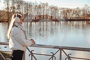 Teenage girl looking away wearing casual fall clothes in an autumn park with lake outdoors