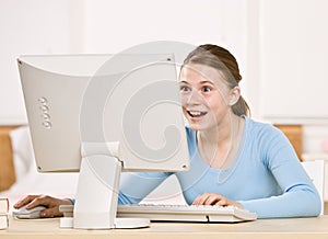 Teenage girl looking at computer monitor