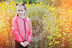 A teenage girl looking for an exit from the forest where she stands in high grass after she got lost in the woods