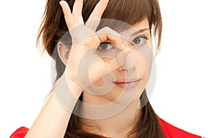 Teenage girl looking through hole from fingers