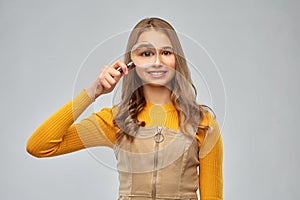 Teenage girl looking through magnifying glass