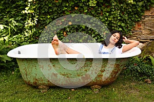 Teenage girl lying in bathtub