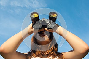Teenage girl observing nature with binoculars