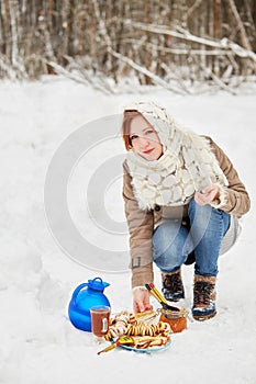 Teenage girl opens glass jar with honey near blue