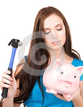 Teenage girl with piggy bank and hammer