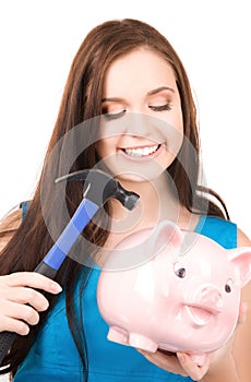 Teenage girl with piggy bank and hammer