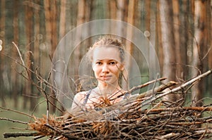 Teenage girl with pimple skin collect branches firewood for a campfire while traveling through a summer forest in nature. young ha