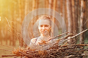 Teenage girl with pimple skin collect branches firewood for campfire while traveling through summer forest in nature. young happy