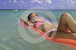 Teenage girl in pink bikini floating