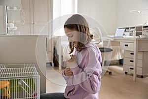 Teenage girl play with domesticated mouse pet at home photo
