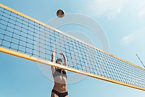 Teenage girl playing beach volleyball. Beach volleyball championship. woman reaches for the ball. throwing a yellow