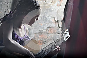 Teenage girl playing guitar