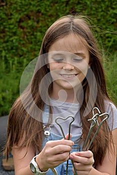 Teenage girl plays with tent pegs