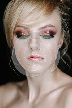 Teenage girl portrait looking down. Beauty Make-up with glitter brown and green eye shadows