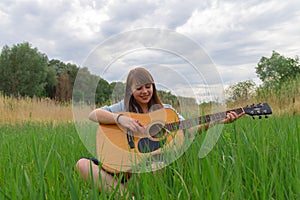 Teenage girl portrait photography with acoustic guitar model posing outdoor green field peaceful summer June day time nature