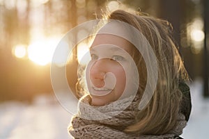 Teenage girl portrait in winter pine forest is sunset