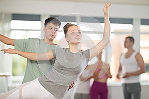 Teenage girl practicing ballet positions in pair with boy in dance studio