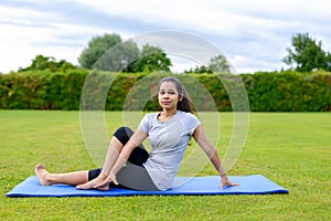 Teenage girl practising yoga outdoors
