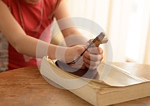 teenage girl praying to God holding a wooden cross,focus on cross.Concept of hope,faith and love