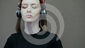 Teenage girl puts on wireless headphones and enjoying music, dancing