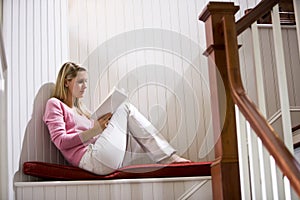 Teenage girl quietly relaxing and reading book