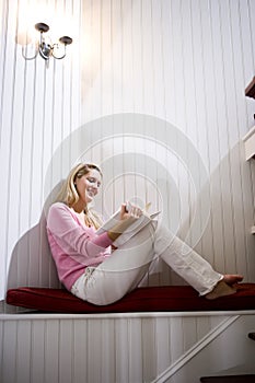 Teenage girl quietly relaxing and reading book