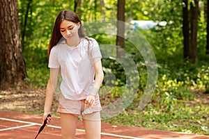 Teenage girl with racket playing badminton in ruck in summer,sport and fitness outdoor