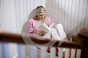 Teenage girl reading alone in quiet corner