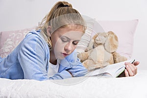 Teenage girl reading on a bed