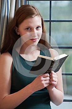 Teenage Girl Reading Bible At Home