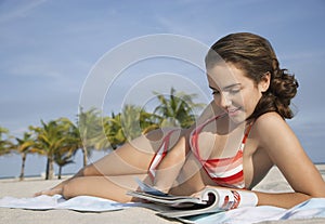 Teenage Girl Reading Magazine On Beach