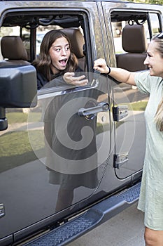 Teenage girl receiving car keys from her mother. After getting her drivers license and a new car this teen girl is super excited t