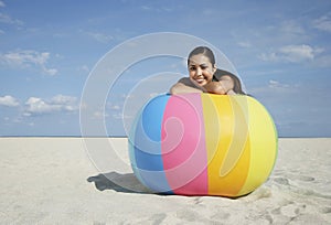 Teenage Girl Relaxing On Large Colorful Beach Ball