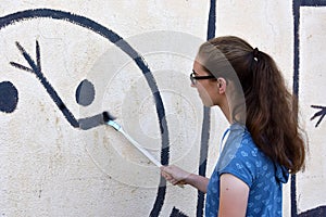 Teenage girl repairs wallpainting photo