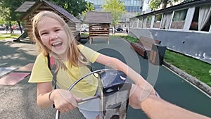 Teenage girl rides a carousel on the playground.