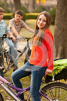 Teenage girl riding bicycles with her friends