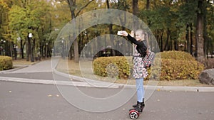 A teenage girl is riding an electronic scooter. the girl dances on gyroscope