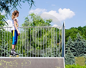 Teenage girl in rollerblades on a ramp