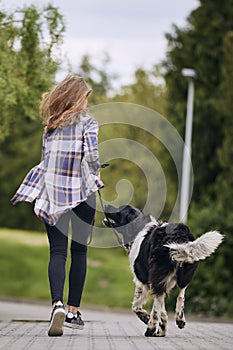 Teenage girl running with her dog