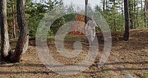 A teenage girl runs with a dog along a path in a pine forest.