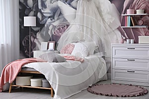 Teenage girl`s room interior with bed and floral wallpaper. Idea for stylish design